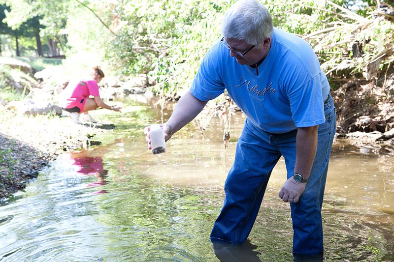 Teachers test water in a stream.