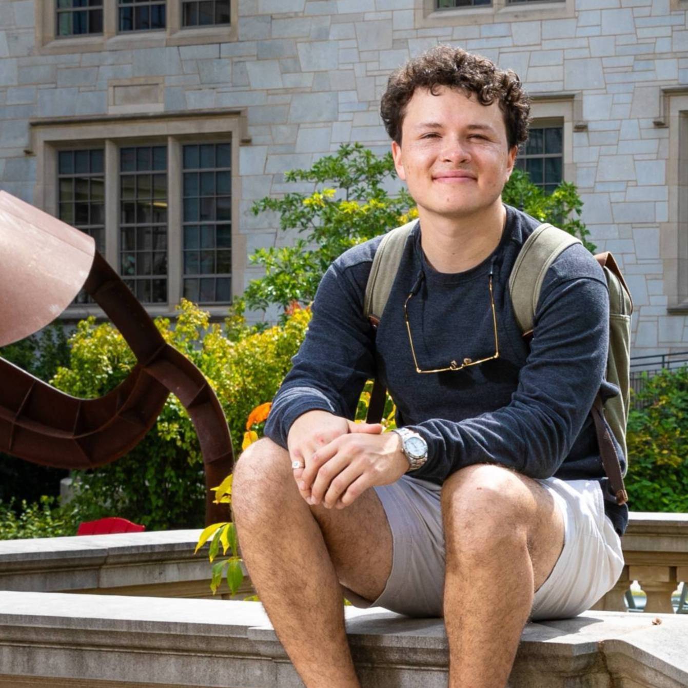 Caleb Flores sitting outside Gearhart Hall. 