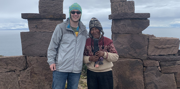students poses with Peruvian man