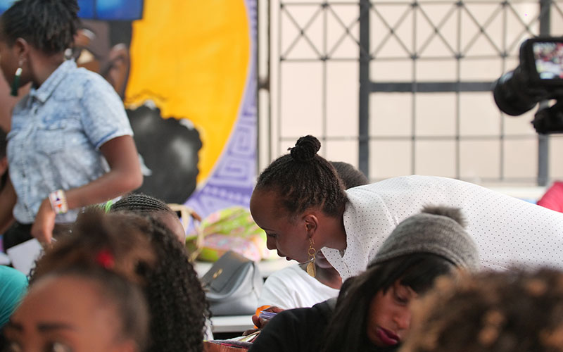 Woman assists students in a classroom