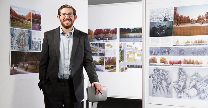 Young man stands in front of design boards 