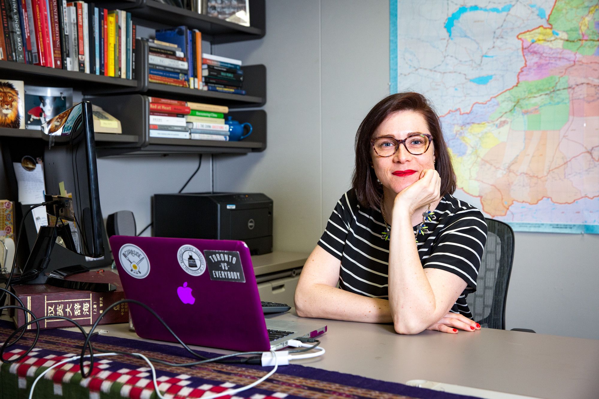 Woman rests chin on fist at desk