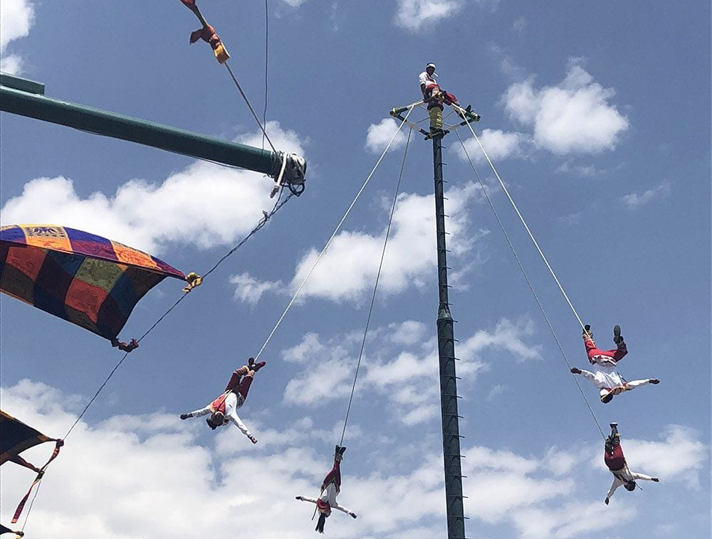 men fly in air in carnival performance