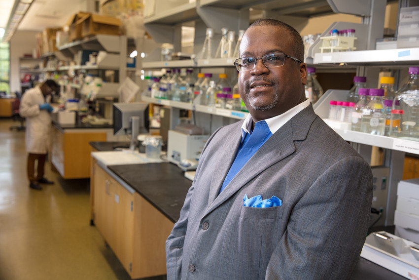 Man in suit standing in chemistry lab