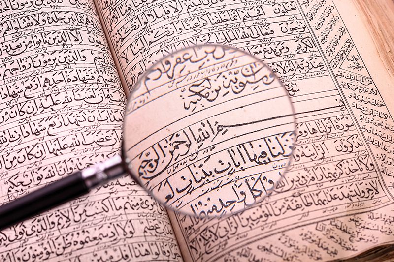 magnifying glass hovering over pages of the Quran