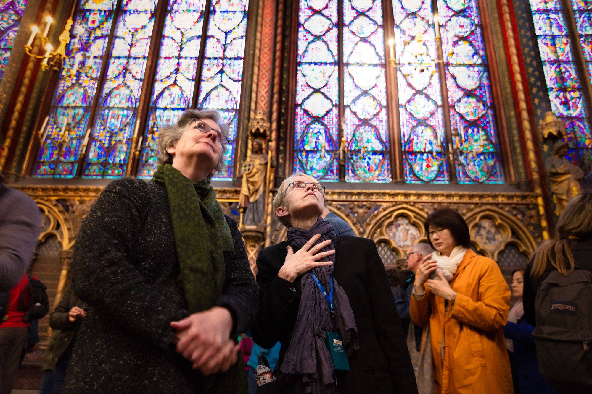 Two women gaze at stained glass