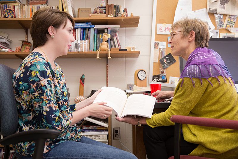 A student visits with her mentor in mentor's office.