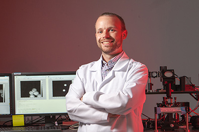 Man in white coat is shown in lab