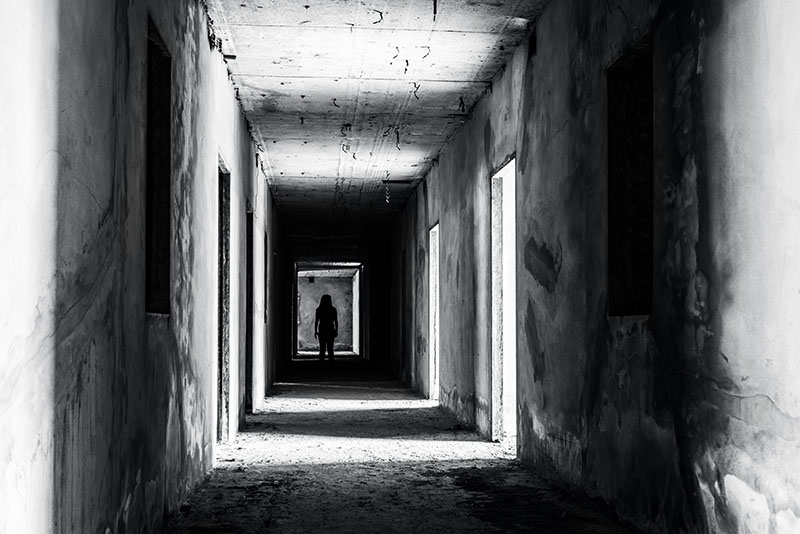 creepy black-and-white of silhouette at end of long hallway