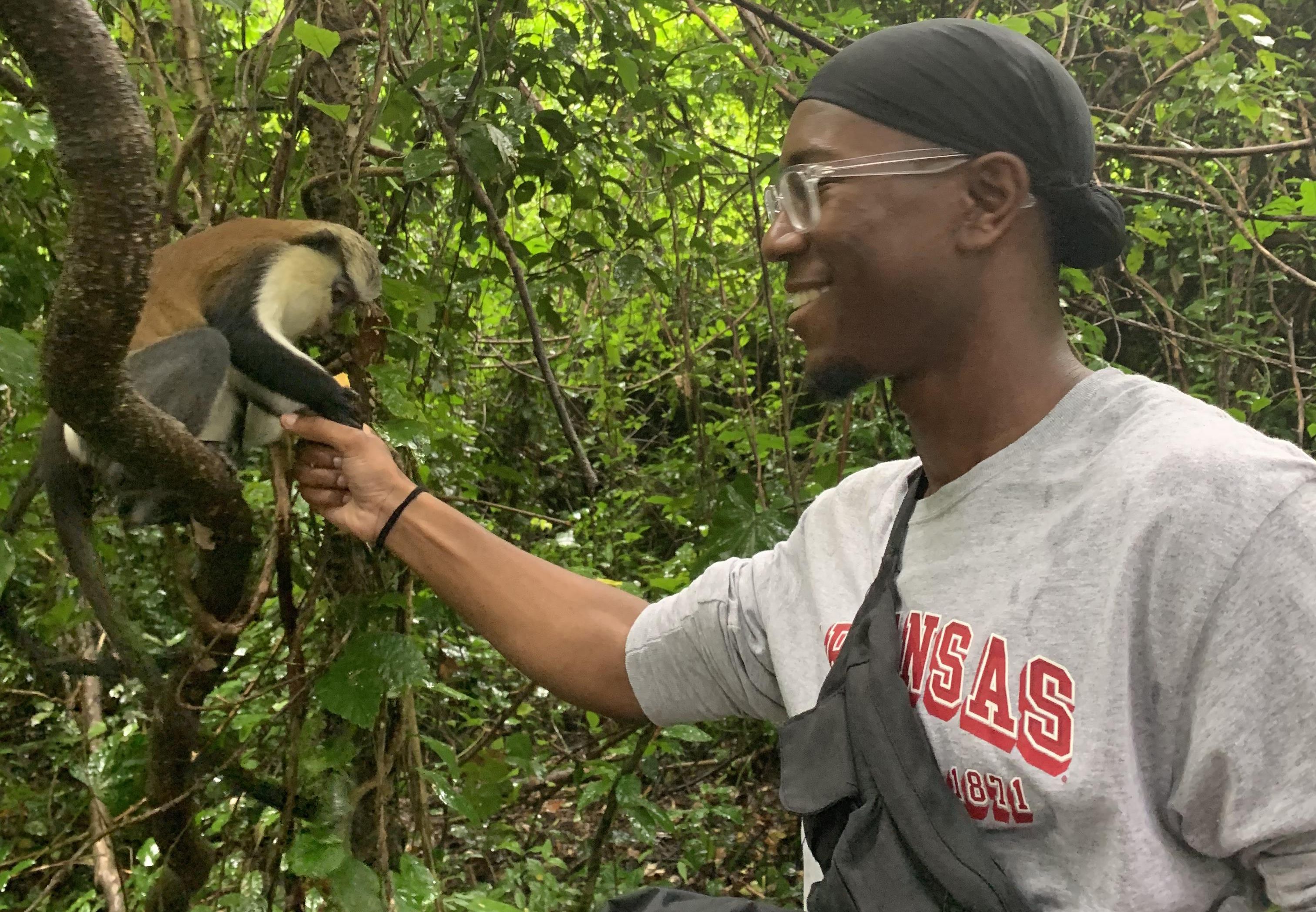 Man feeds monkey in jungle