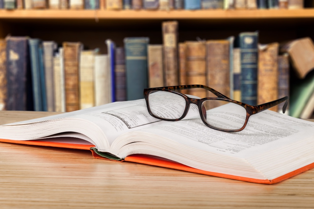 photo of law books with a pair of glasses