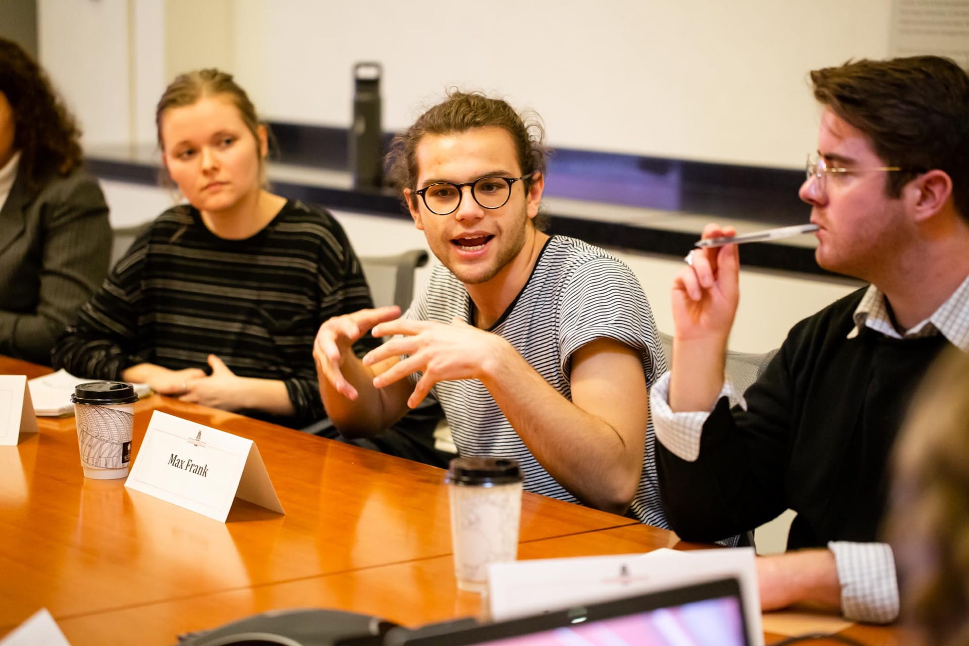 male student speaks at table