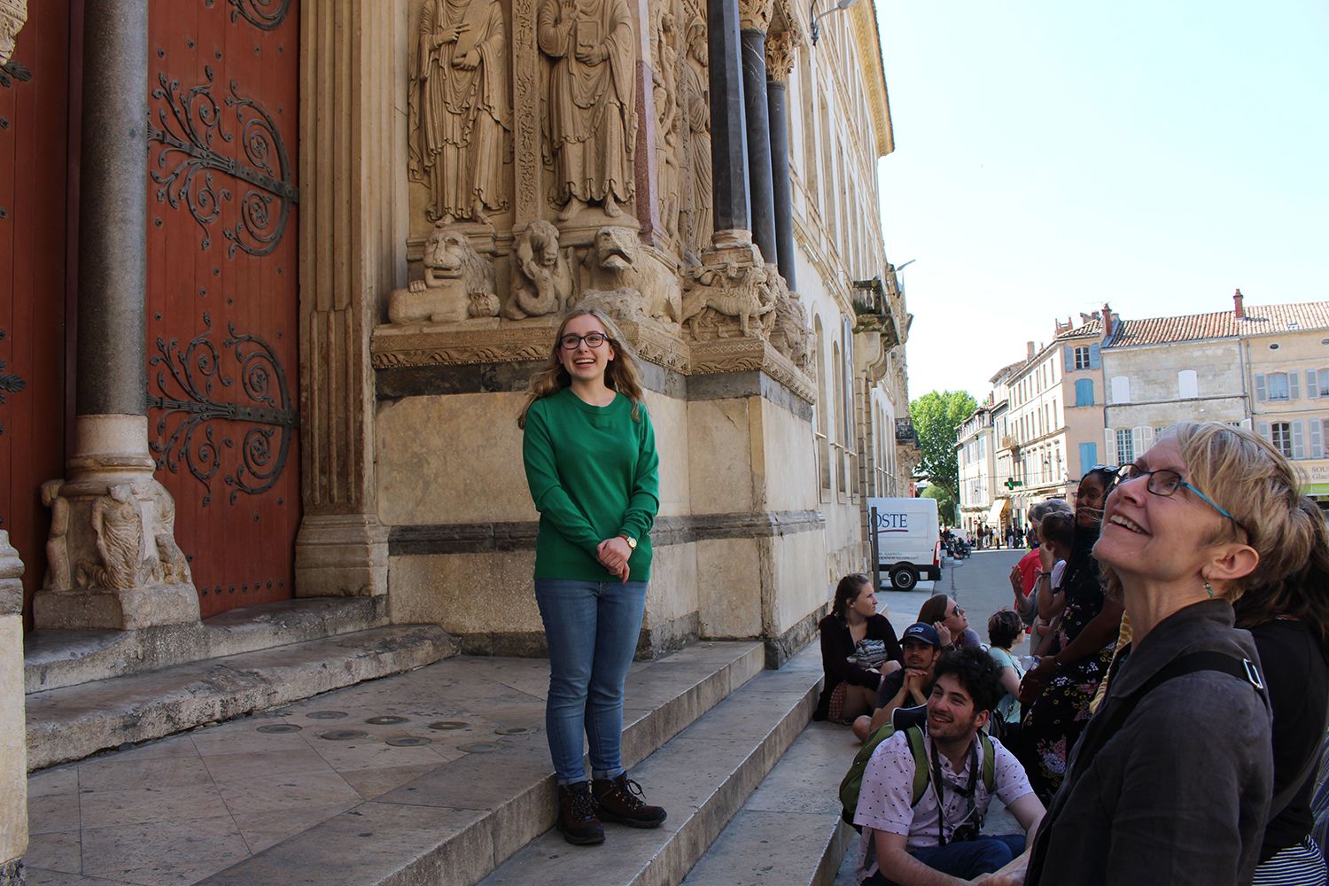 young woman standing at portal of Medieval church