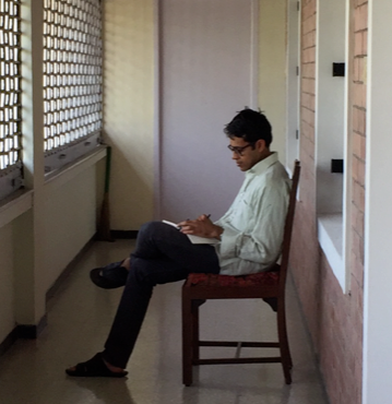 man sitting and writing in hallway