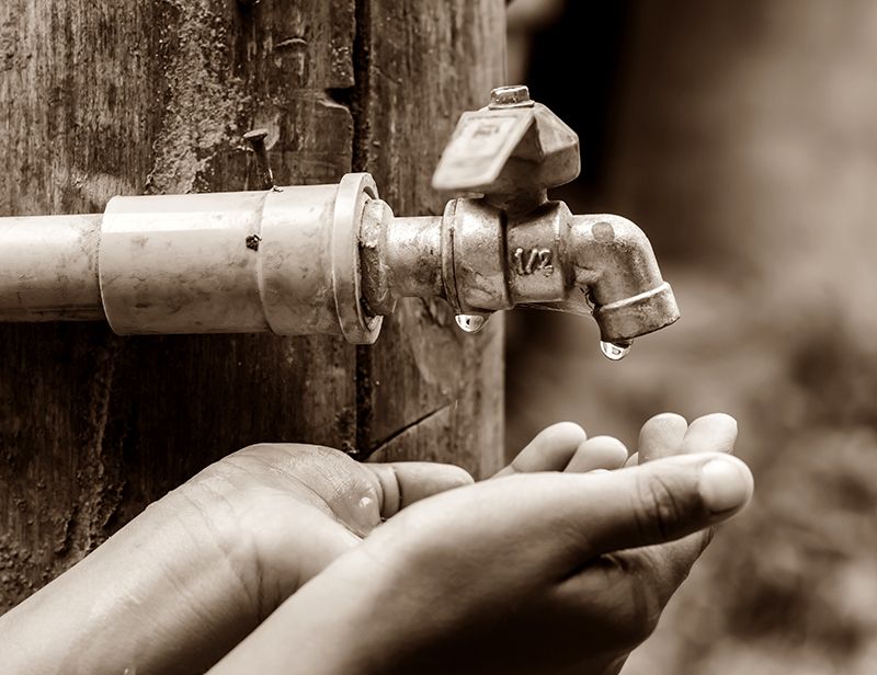 black and white photo of water faucet